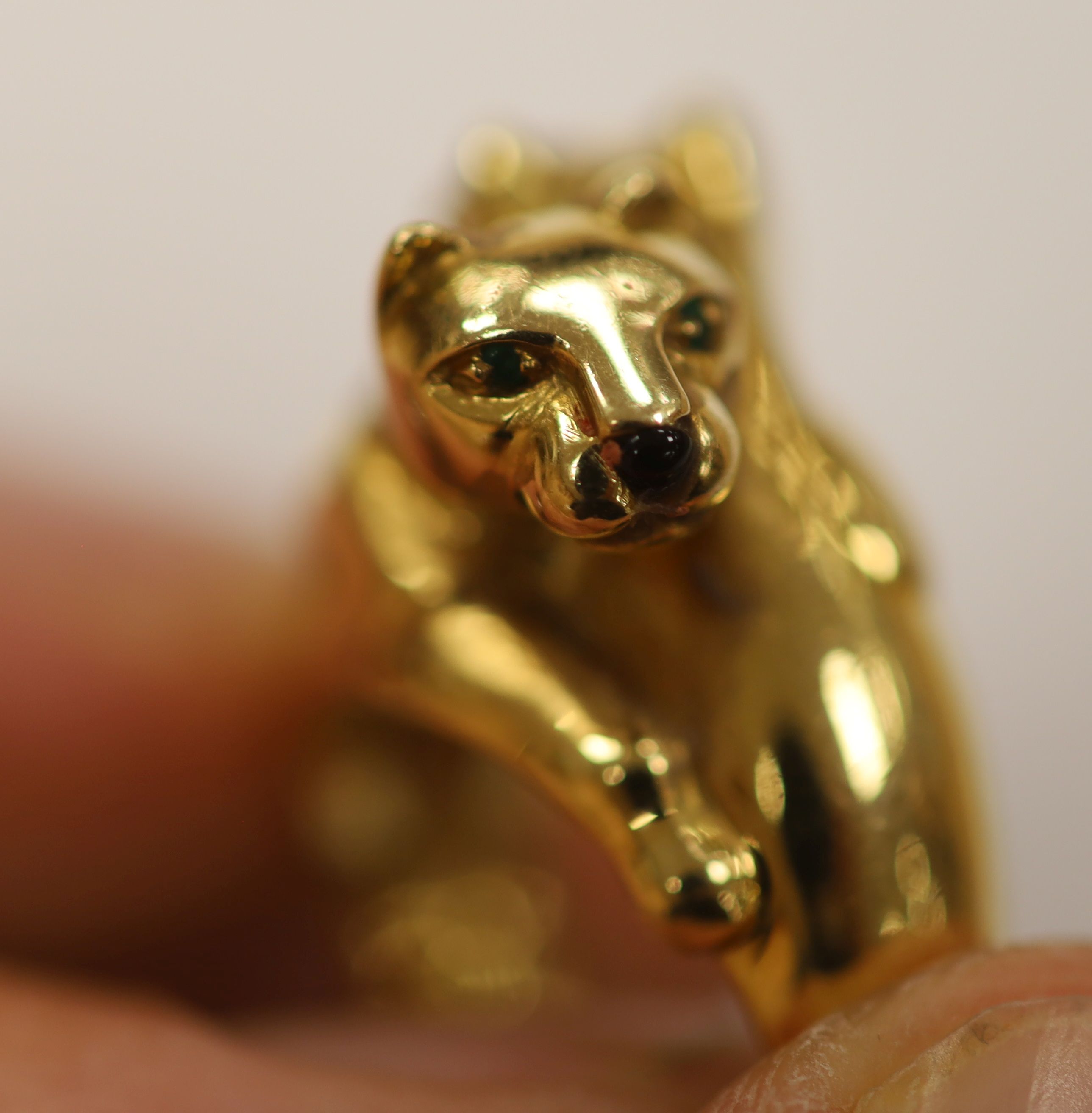 An early 1990's Cartier 18ct gold, black onyx and emerald set twin leopard's head crossover ring